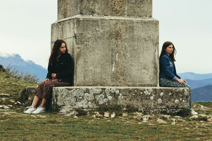 Two women sitting on a monument
